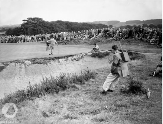 1949 Ryder Cup Match played at Ganton Golf Club. Walkie talkie radio sets were used to send the latest scores of each match back to the scoreboard. In the background, Sam Snead of the USA putts, watched by Charlie Ward.