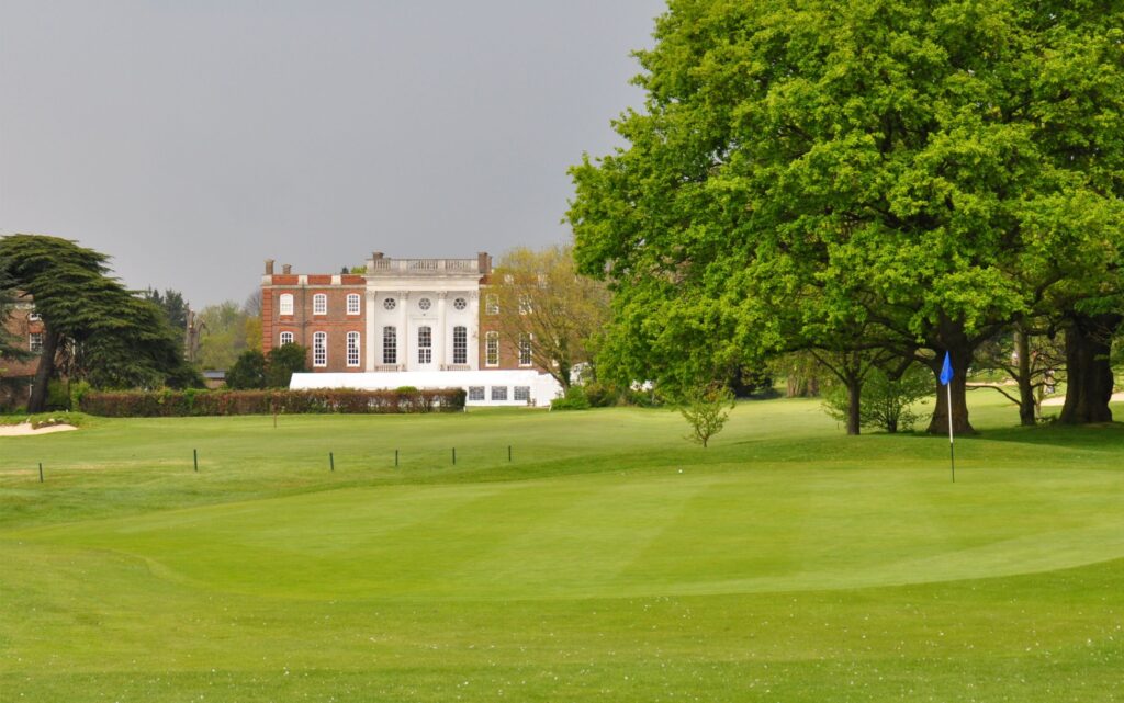 Photograph of the Richmond GC Clubhouse and the 8th Green (Attribution Theobaldg, CC BY-SA 3.0 , via Wikimedia Commons)