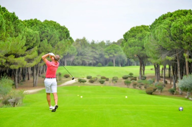 Photograph of a solo golfer teeing off