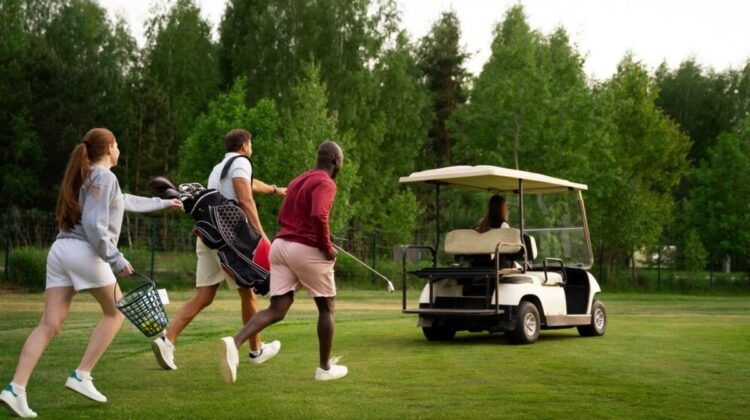 Photograph of three golfers chasing a golf buggy, driven by the other golfer in their group
