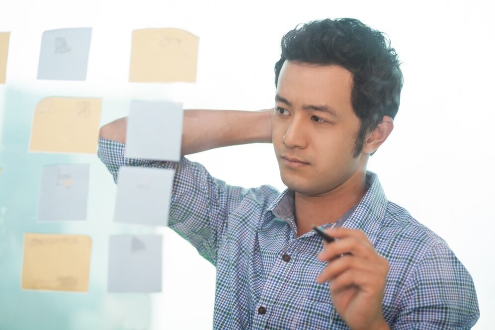 Photograph of a gentleman panning a project (or in this case a golf trip) on a virtual whiteboard